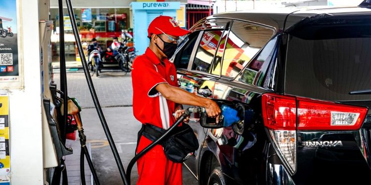 Petugas stasiun pengisian bahan bakar umum (SPBU) tengah mengisi bahan bakar minyak (BBM) ke sebuah kendaraan bermotor. Foto: Dokumen INDOPOS.CO.ID