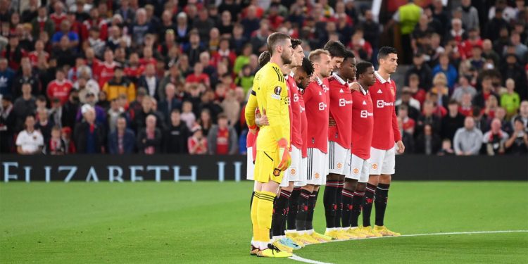 Para pemain dan pendukung Manchester United mengheningkan cipta selama satu menit sebelum bertanding melawan Real Sociedad Kamis (8/9/2022) malam sebagai bentuk penghormatan atas meninggalnya Ratu Elizabeth II. Foto: skysports.com