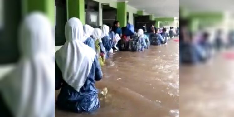 Tangkapan layar video amatir memperlihatkan para murid dievakuasi saat banjir rendam sekolah MTsN 19 Pondok Labu, Jakarta Selatan. Foto: Media Sosial