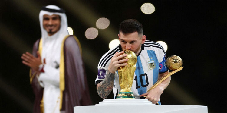 Lionel Messi dari Argentina mencium trofi Piala Dunia usai menerima  penghargaan Bola Emas sebagai pemain terbaik. Foto: news.sky.com