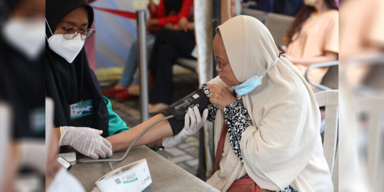 Seorang ibu lansia di Kota Tangerang diperiksa tekanan darahnya oleh tim medis sebelum divaksin Covid-19. (Humas Pemkot Tangerang)