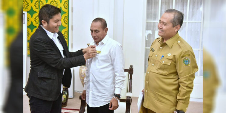 Direktur Infrastruktur Ekosistem Syariah Komite Nasional Ekonomi dan Keuangan Syariah (KNEKS) Sutan Emir Hidayat menyematkan pin kepada Gubernur Edy Rahmayadi, usai penandatanganan pembentukan Komite Daerah Ekonomi dan Keuangan Syariah (KDEKS) ke-11 di Sumatera Utara. Foto Istimewa