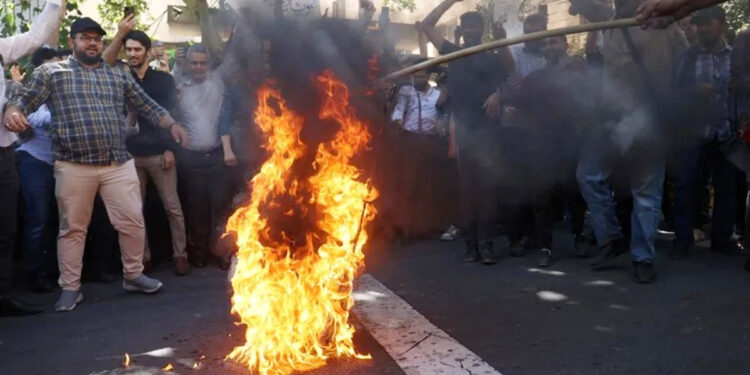 Demonstran di Teheran, Iran membakar bendera Swedia selama protes terhadap penodaan Al Qur'an. Foto: Al Jazeera