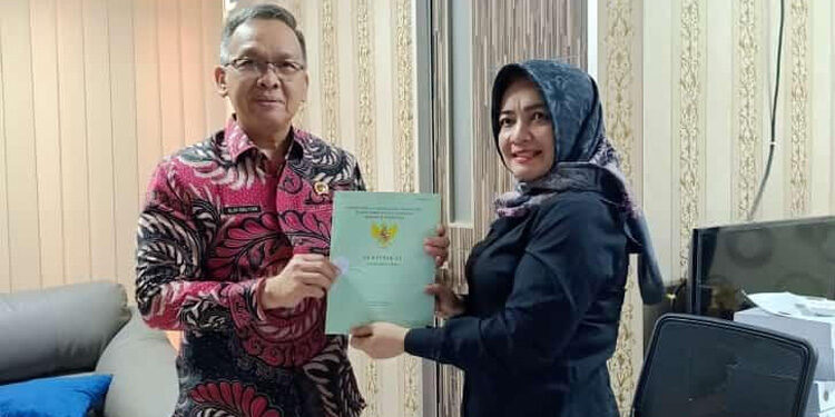 Kepala Badan Pertanahan Nasional (BPN) Kota Padang Alim Bastian (kiri) menyerahkan sertipikat milik Elvy yang sudah diurus sejak 13 tahun lalu. Foto: Istimewa