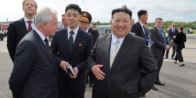 Presiden Korea Utara Kim Jong-un (tengah) tersenyum saat mengunjungi Pabrik Penerbangan Yuri Gagarin di Komsomolsk-on-Amur, Rusia pada hari Jumat (15/9). Foto: KCNA