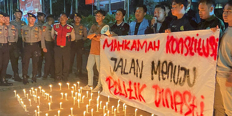 BEM Nusantara menggelar aksi simbolik pemasangan seribu lilin sambil membawa banner bertuliskan ‘Mahkamah Konstitusi Jalan Menuju Politik Dinasti’ di depan Gedung MK, Jakarta, Selasa (17/10/2023) malam. Foto: Istimewa