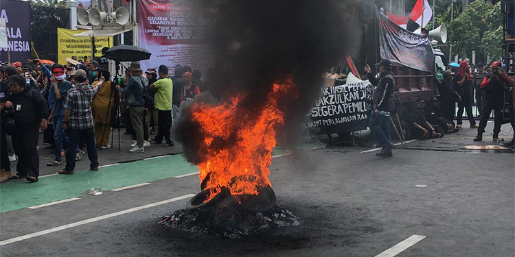 Massa aksi membakar ban bekas di tengah demonstrasi di depan Gedung DPR/MPR, Jakarta. Foto: Indopos.co.id / Dhika Alam Noor