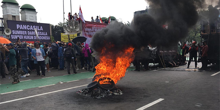 Massa aksi tolak Pemilu curang membakar ban bekas di tengah demonstrasi di depan Gedung DPR/MPR, Jakarta. Foto: Indopos.co.id/Dhika Alam Noor