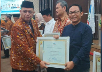 Ketua Umum AGPAII Pusat Drs. H Endang Zaenal M.Ag menyerahkan piagam penghargaan sebagai tokoh inspiratif kepada Ketua Komisi I DPRD Banten A Jazuli Abdillah.  (ist)